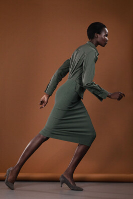 Model in a green dress mid-stride against a rust orange backdrop, Le Mile Magazine editorial by Filip Freytag 